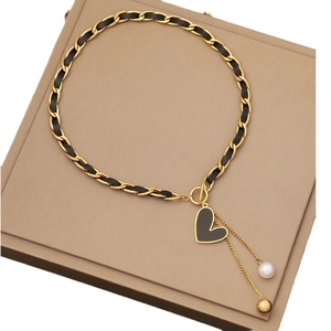 Golden chain and black cord necklace with heart pendant and pearl tassel detail