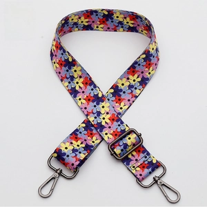 Detail of woven floral shoulder strap with gunmetal swivel hooks and adjustable buckle