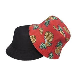 Detailed view of the reversible sun hat with black side and tropical pineapple pattern