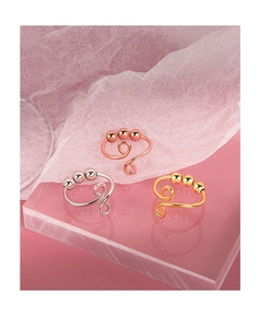 Detailed view of rotating beads on gold, silver, and rose gold anxiety relief rings