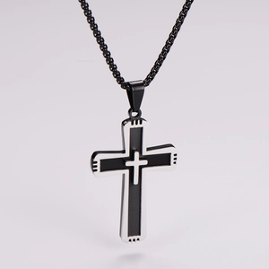 Detailed view of punk cross pendant with two-tone silver and black steel finish