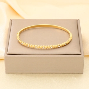 Primo piano di un elegante bracciale in acciaio inossidabile placcato oro 18K con zirconi