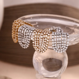 Macro detail of 18K gold and silver plated tassel earrings with micro-inlaid cubic zirconia