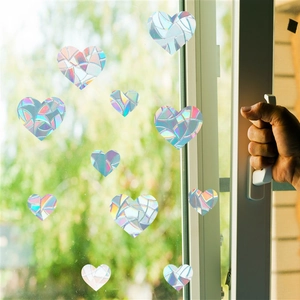 Close-up of heart-shaped rainbow prism window clings with holographic static effect