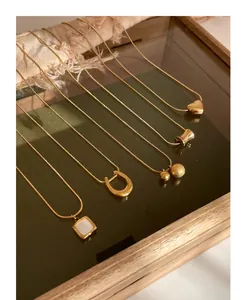 Detailed collection of five golden titanium steel necklaces with minimalist pendants