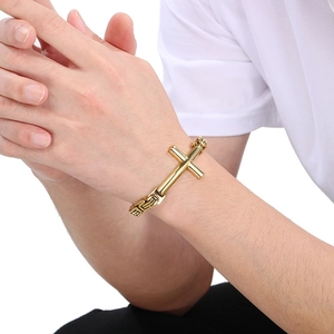 Detail of a chunky gold Byzantine cross bracelet for men with a polished finish