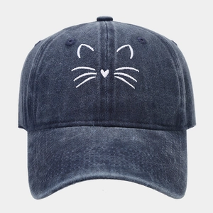 Close-up of white cat whiskers embroidery on washed denim dark blue baseball cap
