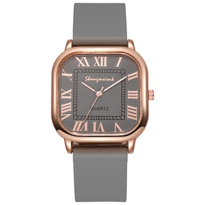 Détail de la montre à quartz carrée avec boîtier or rose et cadran gris à chiffres romains