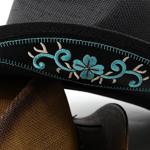 Détail macro d'un chapeau de paille bohème avec broderie florale et texture tissée