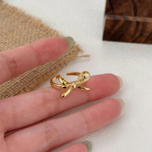 Elegant gold bow-shaped open adjustable ring in 925 sterling silver worn on a finger