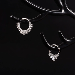 Detailed view of silver stainless steel nose rings with zircon on black display
