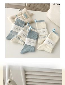 Detail of cream and baby blue striped crew socks with knit texture and heart labels