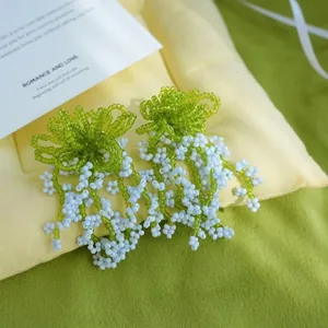 Vue macro de boucles d'oreilles faites main avec pampilles de perles bleues sur coussin