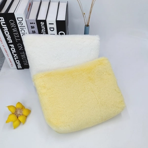 Close-up of soft macaron plush storage bags in white and yellow with faux fur texture