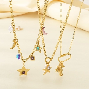 Collier doré étoile et lune avec perles d'imitation et pierres colorées sur fond de soie chaude