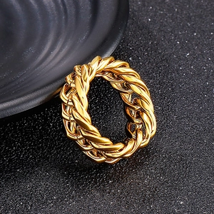 Macro shot of gold Cuban link chain ring with polished mirror finish on dark texture