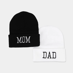 Winter knit beanies set featuring black MOM and white DAD embroidery in a flat lay view