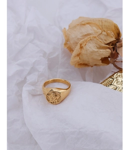 Macro shot of gold signet ring featuring a vintage embossed cherub angel design