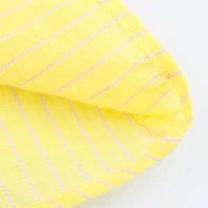Dettaglio macro del tessuto in cotone a righe giallo limone con cuciture taglia-cuci