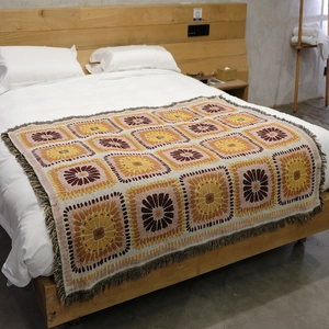 Detailed macro view of bohemian knit blanket with vintage granny square floral patterns