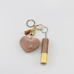 Detail of champagne gold heart keychain with diamond rhinestones and brown leather tassel