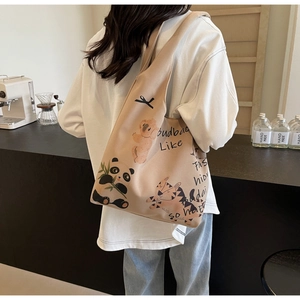 Close-up of canvas tote bag with cartoon panda and tiger patterns in a cafe setting