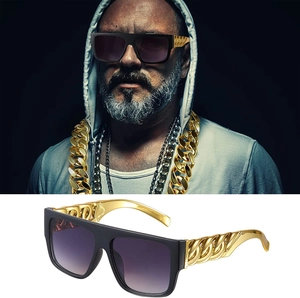 Hip hop sunglasses with thick black frames and gold chain temples on dark and white backgrounds