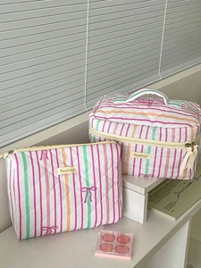 Detailed macro of quilted stripe cosmetic bag set with cute pink bow pattern print