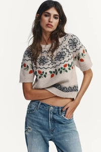 Detail of Christmas style short sleeve knit sweater with snowflake and floral embroidery