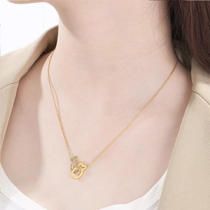 Elegante collana in acciaio inossidabile dorato con ciondolo a pesce e cristalli su modella