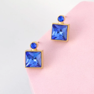 Detail view of square blue crystal earrings with elegant gold-tone metal frame
