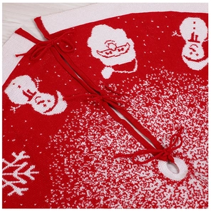 Detail of red and white knitted Christmas tree skirt with festive patterns and lace-up ties