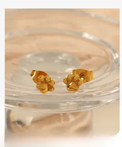 Vue macro de boucles d'oreilles en acier inoxydable doré poli en forme de patte de chat