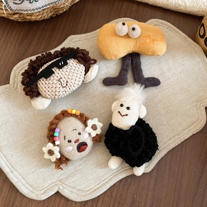 Detailed view of four handmade crochet plush character brooches with Brave embroidery