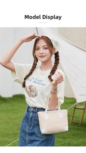 Outdoor shot of a beige plaid tote bag styled with a vintage graphic tee and denim skirt