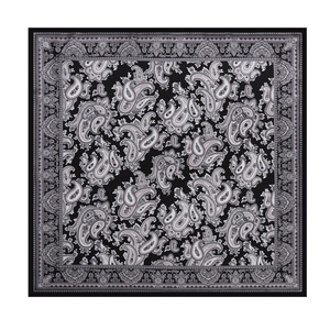 Detailed flat lay of a square scarf showing intricate black and white paisley patterns