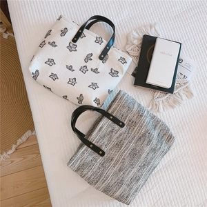 Détail de sacs fourre-tout en toile avec poignées en cuir noir et rivets métalliques