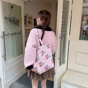 Detailed texture of pink corduroy tote bag with colorful Keep Smiling letter prints