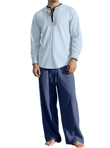 Men's linen set detail showing light blue henley shirt and navy cotton texture trousers