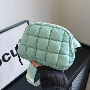Detailed view of the light green quilted waist bag showing the nylon texture and zipper