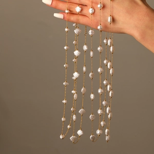Detail of 18k gold plated stainless steel chain with baroque pearls and shell elements