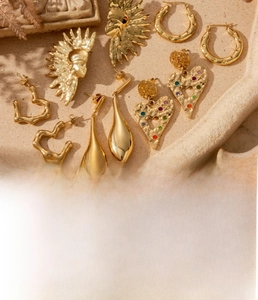 Detailed look at gold-plated titanium earrings with heart and sun designs and zircon stones