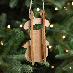 Rustic wooden ski and sleigh Christmas tree ornaments with jute string on pine branches