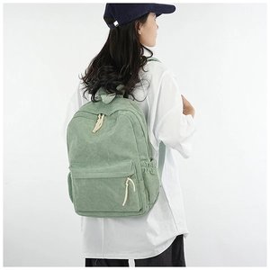 Pale green corduroy backpack shown on model highlighting the minimalist daily style