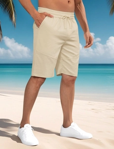 Men's loose sports shorts detail with elastic drawstring waist on a beach background