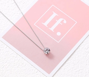 Close-up of sparkling cubic zirconia pendant with four-prong setting and silver box chain