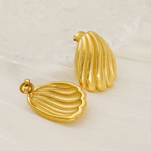 Gros plan sur des boucles d'oreilles coquillage dorées 18 carats sur un fond en soie blanche