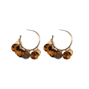 Gold hoop earrings featuring leopard print resin discs and polished metal accents