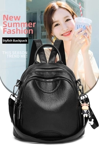 Detail of black pebbled leather backpack with cow charm and Mickey silhouette ribbon