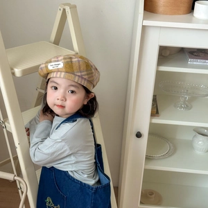 Detail of child wearing a vintage wool plaid beret with yellow and purple check pattern